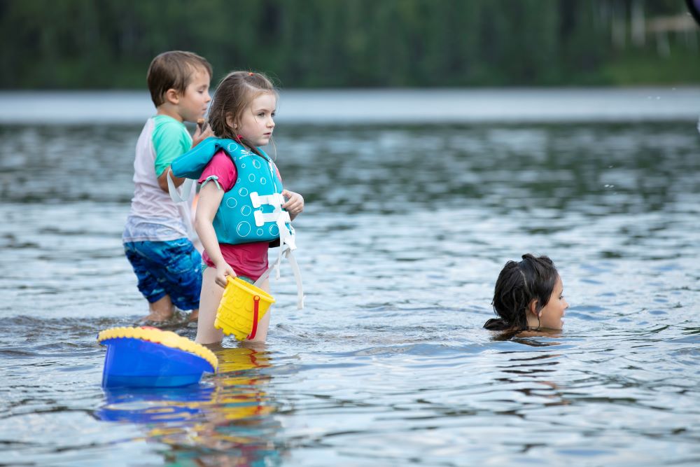 Des enfants jouant sur la plage du petit Lac Laberge